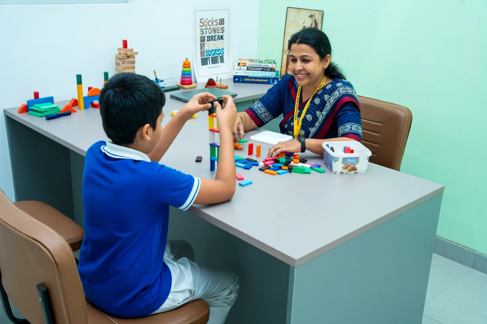 The school counsellor working with a child at a table of coloured building blocks
