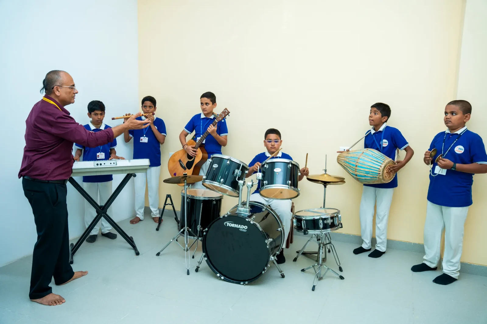 Students playing drums, keyboard, guitar and dholak with their teacher in Rhythm Square
